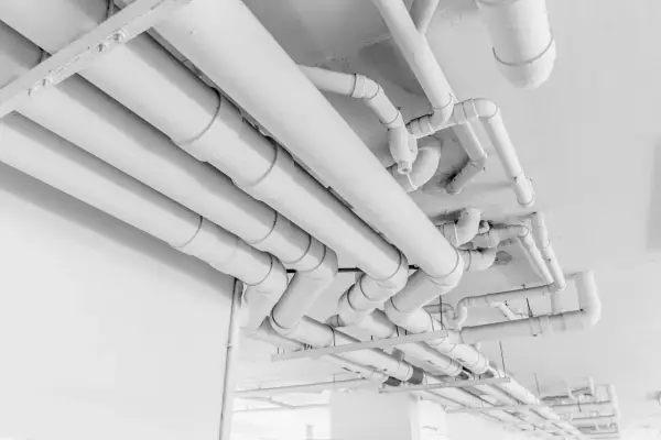 Skomplikowany system białych rur pehd biegnie pod sufitem, tworząc labirynt instalacji.